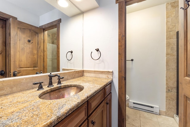 bathroom with baseboard heating, vanity, tile patterned floors, toilet, and walk in shower