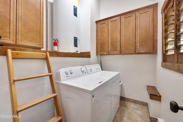 laundry room with cabinets, washing machine and dryer, and light tile patterned floors