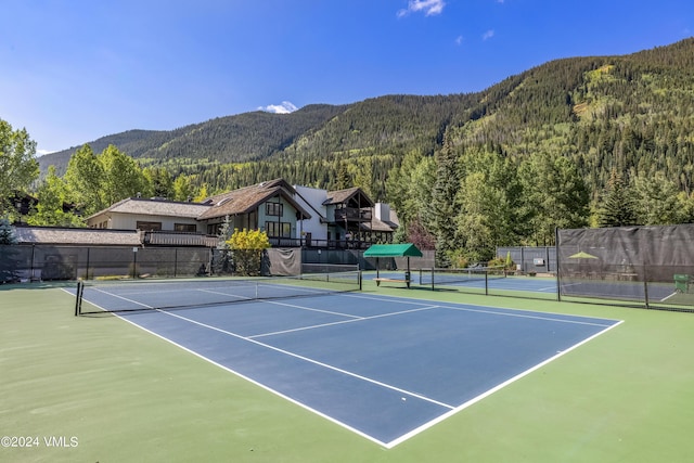 view of tennis court featuring a mountain view