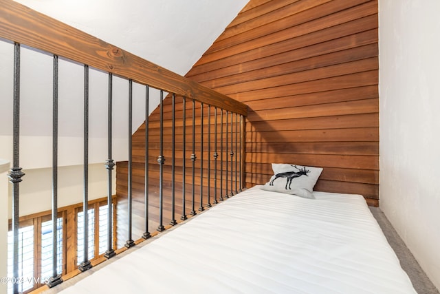 bonus room featuring lofted ceiling and wood walls