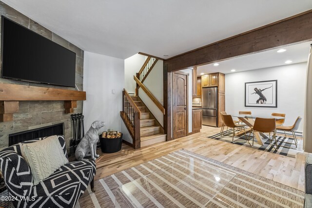 living room featuring a large fireplace and light wood-type flooring