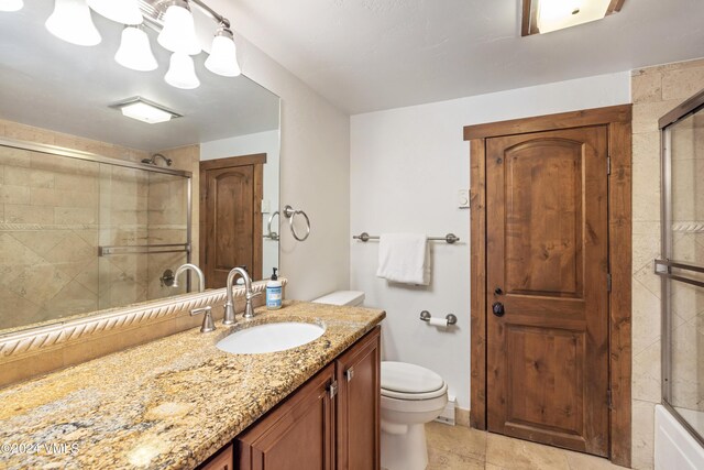 full bathroom featuring shower / bath combination with glass door, tile patterned floors, vanity, and toilet