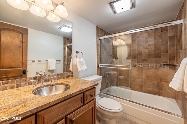 full bathroom featuring bath / shower combo with glass door, vanity, and toilet