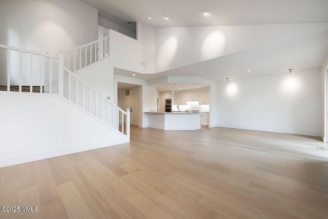 170 Wildflower Unit 12, Edwards, CO 81632 - unfurnished living room featuring stairway, light wood finished floors, high vaulted ceiling, and recessed lighting