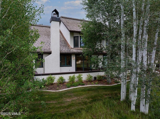170 Wildflower Unit 12, Edwards, CO 81632 - rear view of house with stucco siding, a lawn, and a chimney