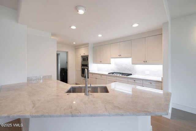 170 Wildflower Unit 12, Edwards, CO 81632 - kitchen with appliances with stainless steel finishes, light stone counters, a peninsula, light wood-style flooring, and recessed lighting