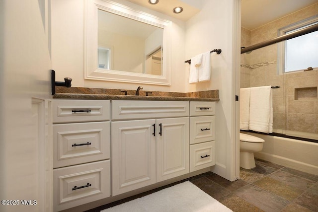 170 Wildflower Unit 12, Edwards, CO 81632 - bathroom featuring vanity, enclosed tub / shower combo, and stone tile floors