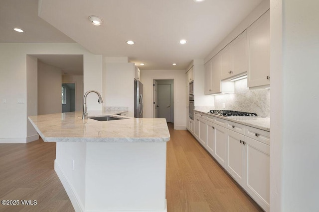 170 Wildflower Unit 12, Edwards, CO 81632 - kitchen with appliances with stainless steel finishes, white cabinetry, a peninsula, light wood finished floors, and recessed lighting