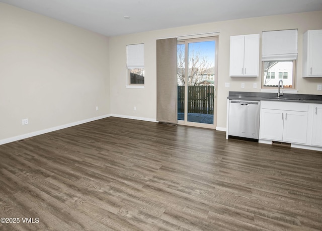 804 Chickadee Ln, Gypsum, CO 81637 - kitchen with stainless steel dishwasher, a sink, dark countertops, open floor plan, and dark wood finished floors