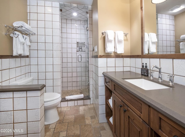 684 W Lionshead Cir Unit 215/216, Vail, CO 81657 - full bath with tile walls, toilet, vanity, a stall shower, and stone tile floors