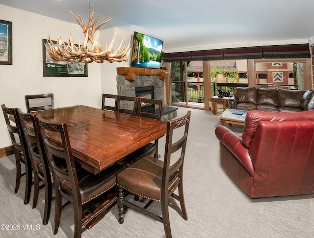 684 W Lionshead Cir Unit 215/216, Vail, CO 81657 - dining space featuring carpet flooring, a stone fireplace, and a chandelier