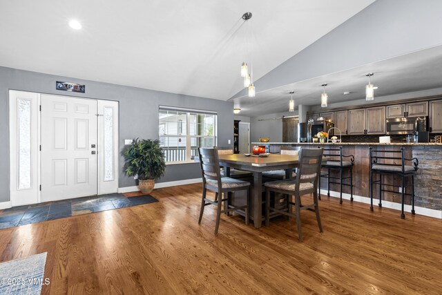 dining space featuring lofted ceiling and dark hardwood / wood-style floors