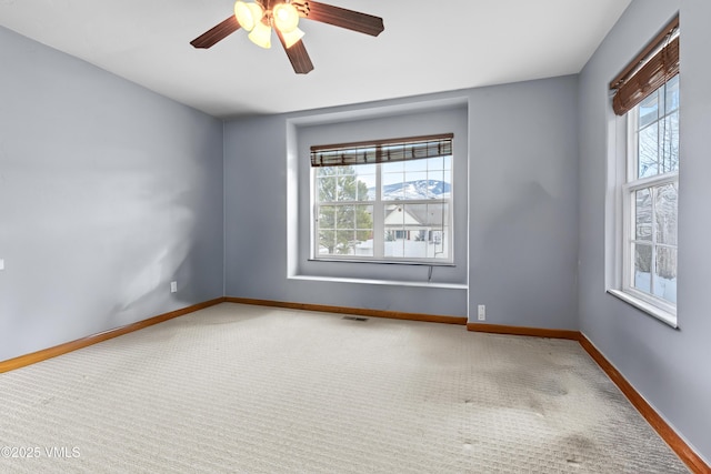 empty room with carpet, plenty of natural light, and ceiling fan