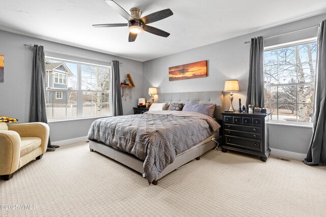 carpeted bedroom with multiple windows and ceiling fan