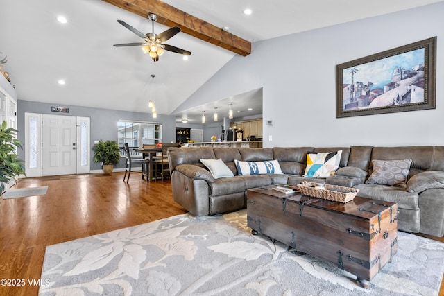 living room featuring beam ceiling, high vaulted ceiling, ceiling fan, and light wood-type flooring