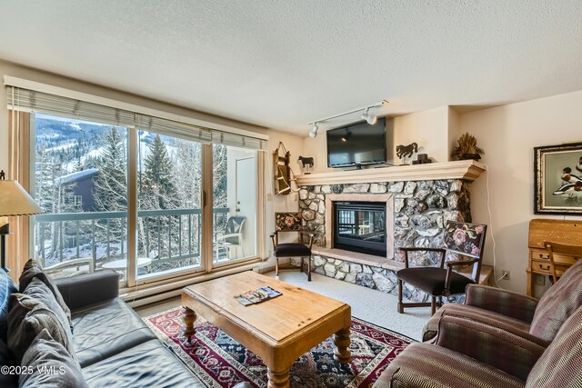 1120 Village Rd Unit 306, Beaver Creek, CO 81620 - living room with a stone fireplace, a textured ceiling, plenty of natural light, and carpet flooring