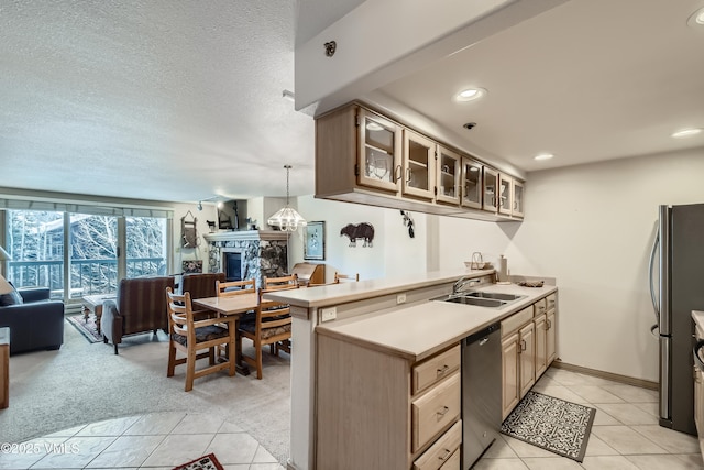 1120 Village Rd Unit 306, Beaver Creek, CO 81620 - kitchen featuring open floor plan, appliances with stainless steel finishes, a sink, a stone fireplace, and light countertops