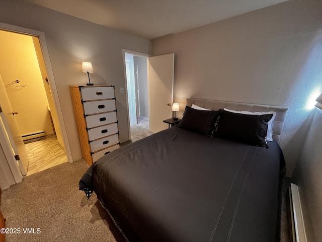 bedroom with light carpet, a baseboard radiator, and baseboard heating