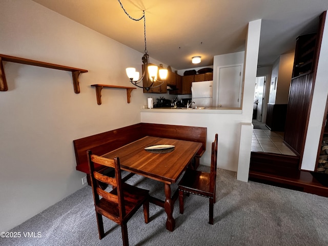 dining room featuring a chandelier and light carpet