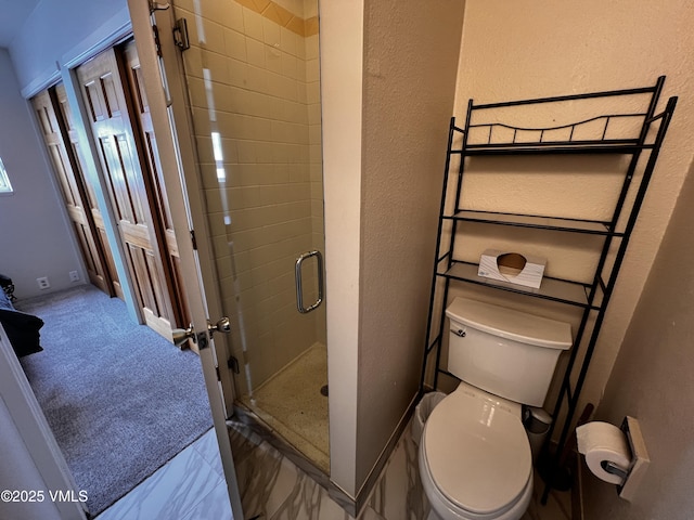 bathroom with toilet, a stall shower, baseboards, and a textured wall