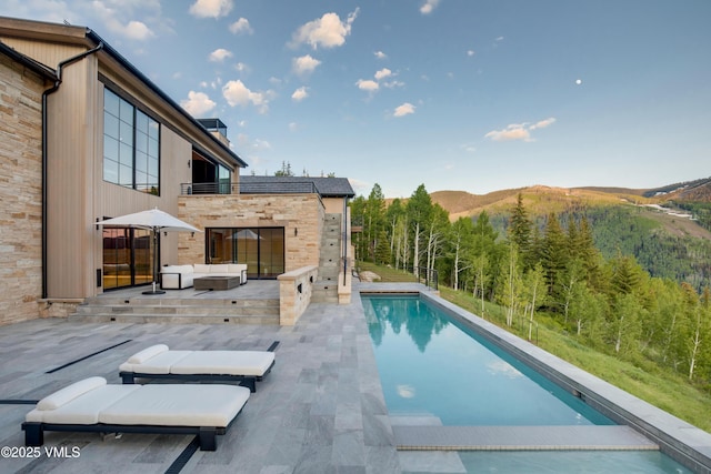 1326 Spraddle Creek Rd, Vail, CO 81657 - swimming pool with an outdoor hangout area, a patio, a mountain view, and a forest view