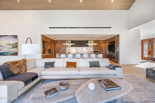 1326 Spraddle Creek Rd, Vail, CO 81657 - living room featuring light wood-style floors, wood ceiling, a towering ceiling, and baseboards