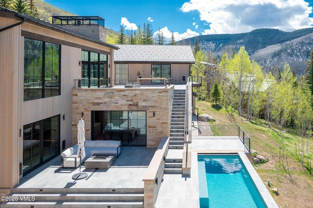 1326 Spraddle Creek Rd, Vail, CO 81657 - swimming pool with stairs, a mountain view, a patio, and an outdoor living space with a fire pit