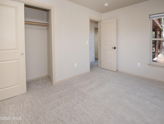 unfurnished bedroom featuring carpet floors, baseboards, and a closet