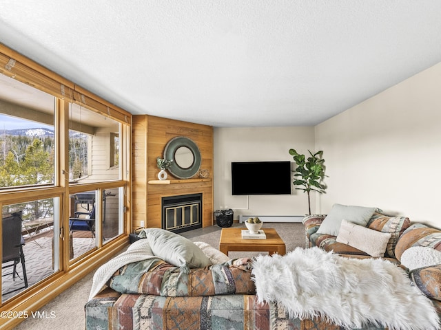 living room featuring a baseboard heating unit, carpet, a large fireplace, and a textured ceiling