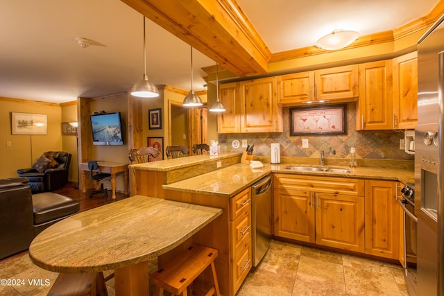 kitchen featuring sink, appliances with stainless steel finishes, a kitchen bar, decorative light fixtures, and kitchen peninsula