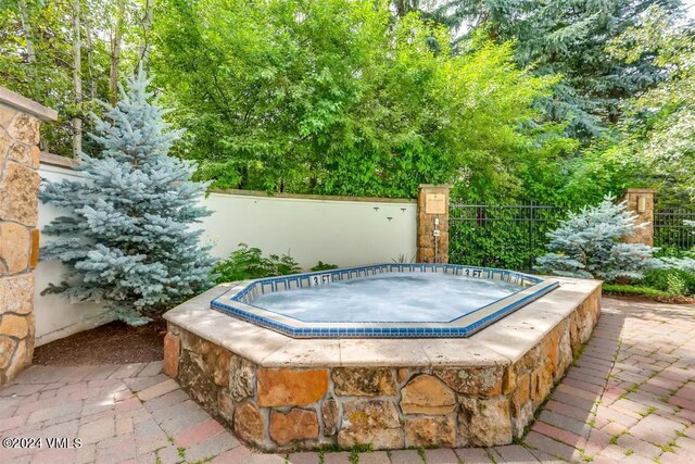 view of pool with an in ground hot tub