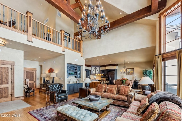 102 Village Walk, Beaver Creek, CO 81620 - living area with a notable chandelier, light wood-type flooring, visible vents, and a high ceiling