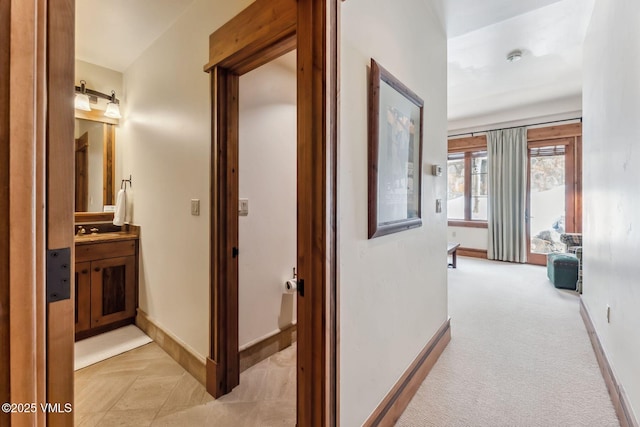 102 Village Walk, Beaver Creek, CO 81620 - hallway featuring light carpet, a sink, and baseboards