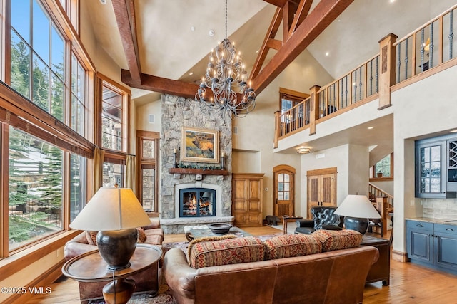 102 Village Walk, Beaver Creek, CO 81620 - living area featuring a chandelier, hardwood / wood-style floors, high vaulted ceiling, and a stone fireplace