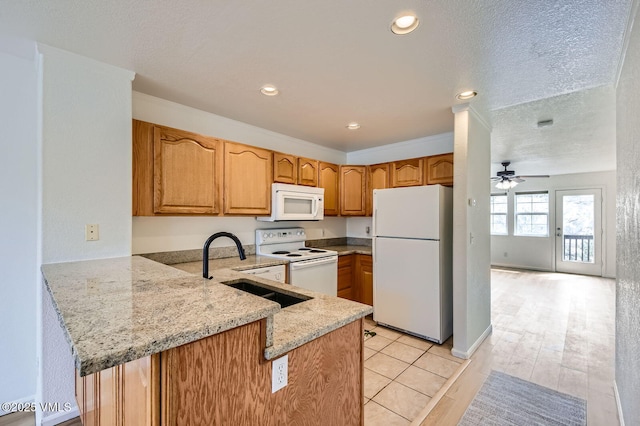 35 Chelsea Ct Unit 9, Eagle, CO 81631 - kitchen featuring light stone counters, a sink, white appliances, ceiling fan, and a peninsula