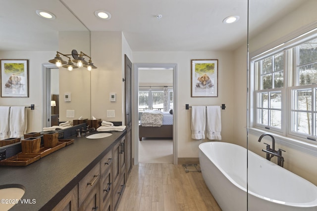 50 Bermuda Dr, Edwards, CO 81632 - ensuite bathroom featuring a soaking tub, recessed lighting, connected bathroom, a sink, and wood finished floors