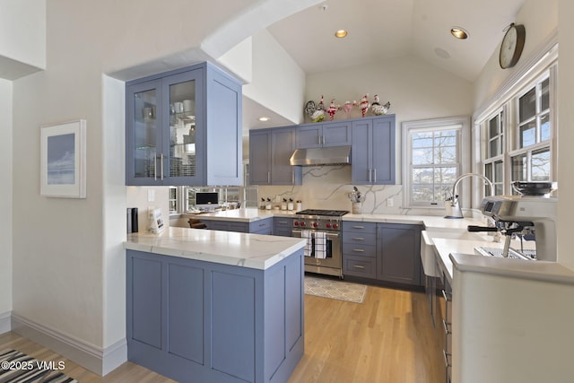 50 Bermuda Dr, Edwards, CO 81632 - kitchen featuring tasteful backsplash, a peninsula, under cabinet range hood, light wood finished floors, and premium stove
