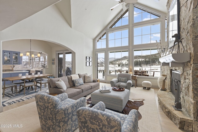 50 Bermuda Dr, Edwards, CO 81632 - living room with arched walkways, a stone fireplace, light wood-type flooring, ceiling fan with notable chandelier, and high vaulted ceiling