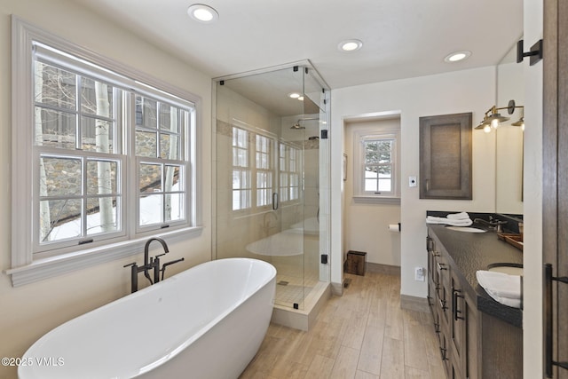 50 Bermuda Dr, Edwards, CO 81632 - full bathroom featuring a freestanding bath, a sink, double vanity, wood finished floors, and a stall shower