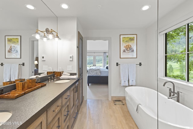50 Bermuda Dr, Edwards, CO 81632 - ensuite bathroom with double vanity, healthy amount of natural light, a soaking tub, recessed lighting, and wood finished floors