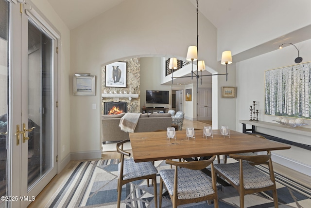 50 Bermuda Dr, Edwards, CO 81632 - dining area with high vaulted ceiling, a fireplace, light wood finished floors, and baseboards