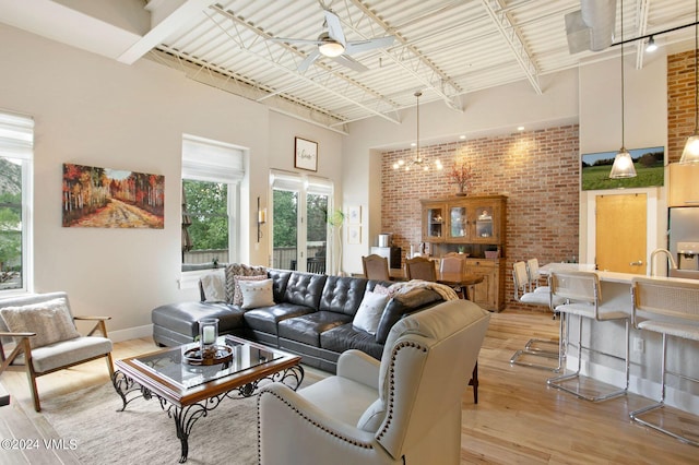 living room with light hardwood / wood-style flooring, track lighting, ceiling fan, and plenty of natural light