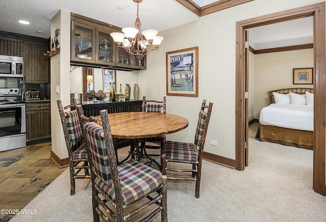 dining room featuring an inviting chandelier, light colored carpet, and ornamental molding