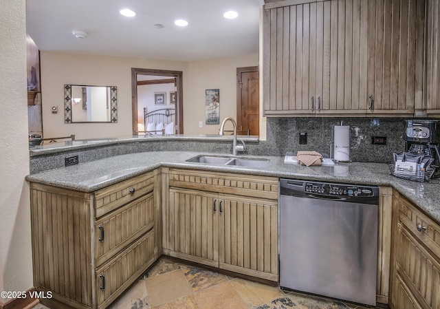 kitchen with stainless steel dishwasher, kitchen peninsula, sink, and decorative backsplash