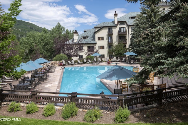 view of swimming pool featuring a patio and a mountain view