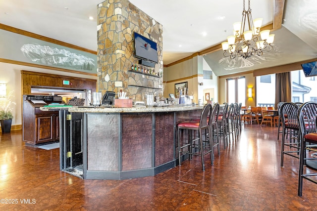 kitchen featuring a kitchen bar, hanging light fixtures, light stone countertops, dark brown cabinets, and an inviting chandelier