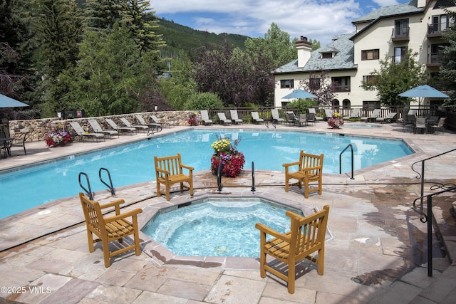 view of swimming pool with a patio area and a hot tub