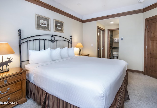 bedroom with connected bathroom and light colored carpet