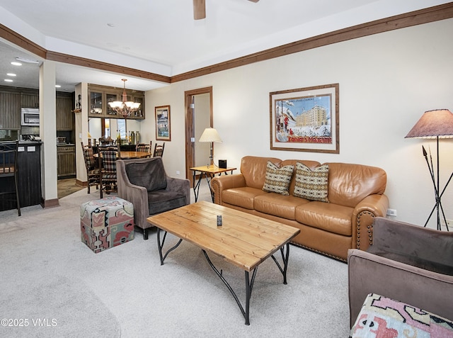 carpeted living room featuring ceiling fan with notable chandelier