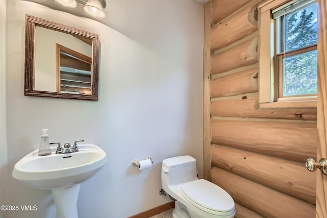 121 Hackamore Rd Unit B, Edwards, CO 81632 - bathroom featuring log walls, toilet, and baseboards